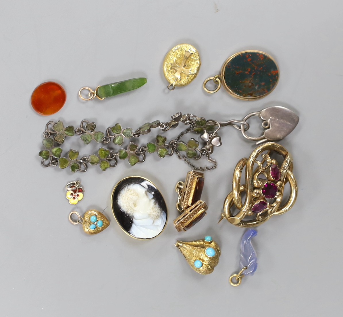 A small group of Victorian and later jewellery including a 1920's silver 'shamrock' bracelet, garnet set scroll brooch, bloodstone set mourning pendant(lacking back), small charms including enamel, sardonyx cameo etc.